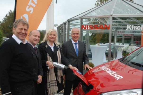 Bürgermeisterin Magareta Ritter ‚tankt‘ den Nissan e-NV200 der Monschauer Feuerwehr. V.l.n.r: Jürgen Kirch (eAutohaus Kirch), Thomas Hausch (Gschäftsführer Nissan Center Europe), Magareta Ritter (Bürgermeisterin Monschau), Dr. Peter Asmuth Vorstand Stawag